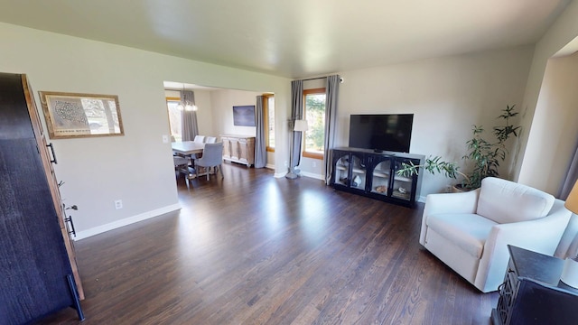 living area featuring dark wood-style flooring and baseboards