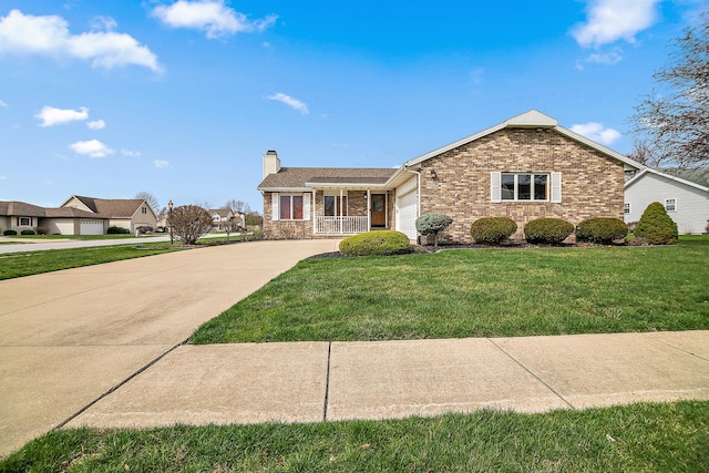 view of front of property with an attached garage, driveway, a front yard, brick siding, and a chimney