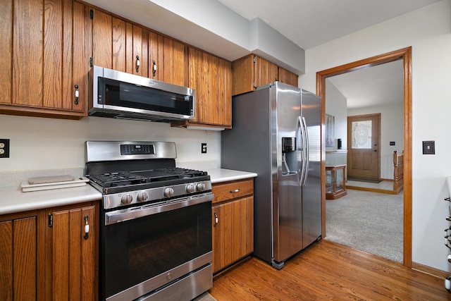 kitchen featuring light countertops, appliances with stainless steel finishes, and brown cabinetry