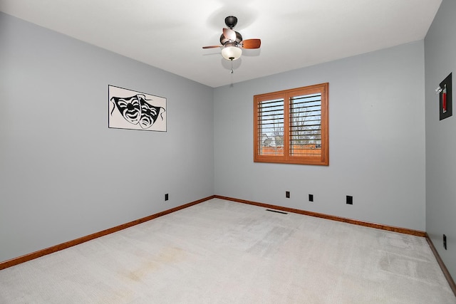 empty room featuring a ceiling fan, light carpet, baseboards, and visible vents