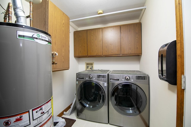 washroom with independent washer and dryer, cabinet space, baseboards, and gas water heater