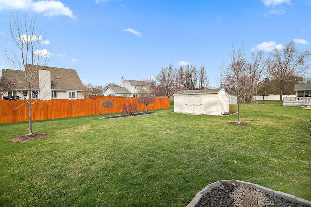 view of yard featuring a fenced backyard, an outbuilding, and a storage unit