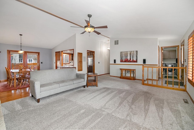 living room with washer / clothes dryer, lofted ceiling, ceiling fan, and visible vents