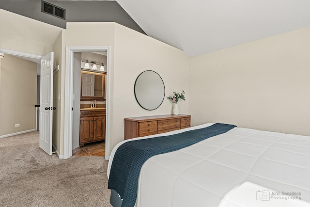 carpeted bedroom featuring visible vents, baseboards, ensuite bathroom, a sink, and lofted ceiling