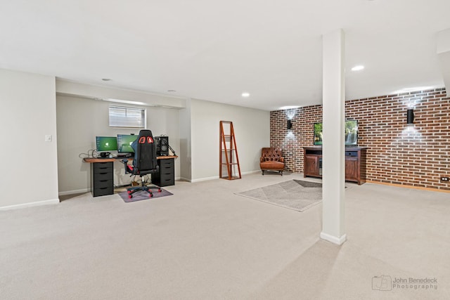 office area featuring brick wall, light carpet, and baseboards