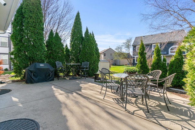 view of patio / terrace with grilling area, outdoor dining area, and an outdoor structure
