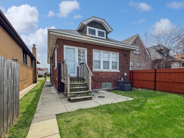608 W 107th St, Chicago, IL 60628 - rear view of property featuring brick siding, central air condition unit, and a patio area