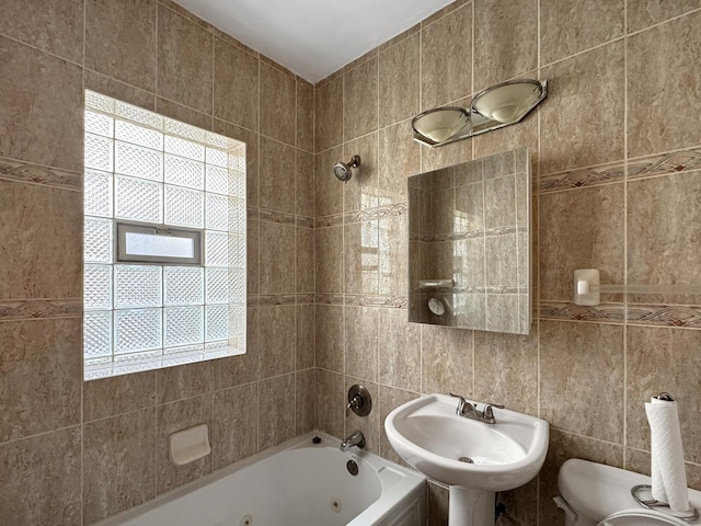 608 W 107th St, Chicago, IL 60628 - bathroom with tile walls, a sink, a combined bath / shower with jetted tub, and toilet