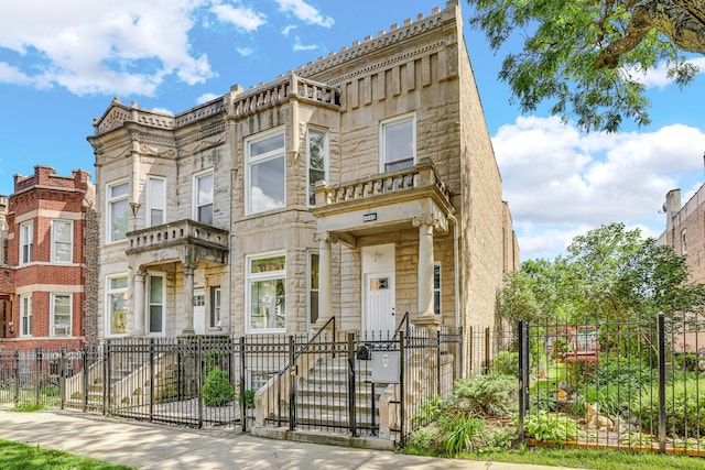 view of property featuring a fenced front yard, stone siding, and a gate