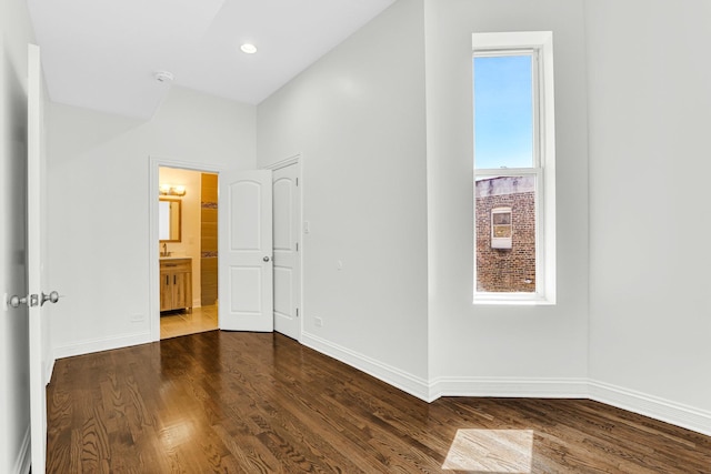 empty room featuring dark wood-type flooring, baseboards, and recessed lighting