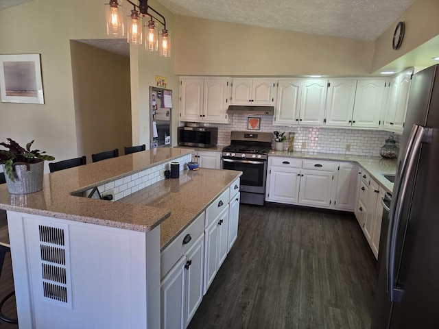 kitchen featuring tasteful backsplash, a textured ceiling, white cabinets, appliances with stainless steel finishes, and under cabinet range hood
