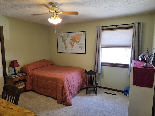 bedroom with a textured ceiling, carpet flooring, a ceiling fan, and visible vents