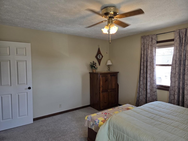 carpeted bedroom with a textured ceiling, ceiling fan, and baseboards