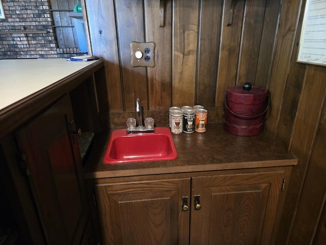 bathroom with wooden walls and a sink