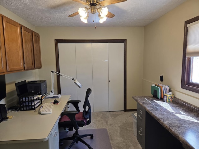 office space with ceiling fan, light carpet, and a textured ceiling