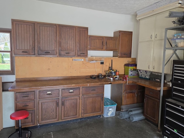 kitchen featuring backsplash, dark countertops, and a textured ceiling