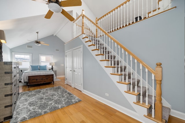 interior space with baseboards, high vaulted ceiling, wood finished floors, and ceiling fan