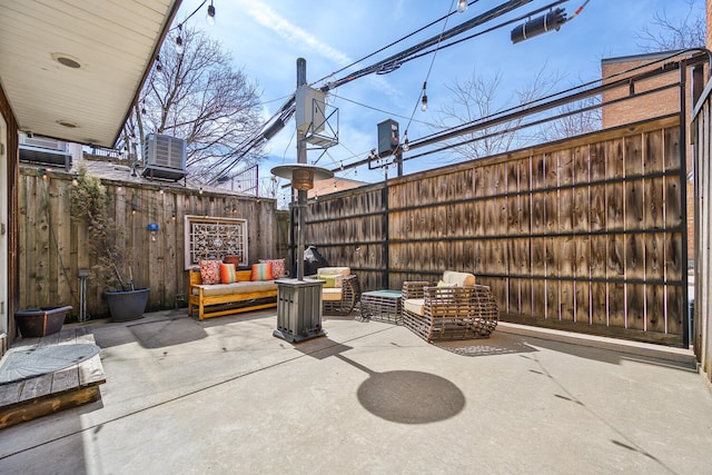 view of patio / terrace featuring a fenced backyard, an outdoor living space, and central AC