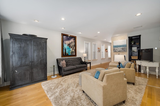 living area featuring baseboards, light wood-style floors, and recessed lighting