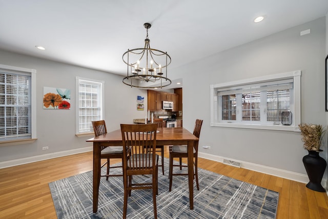 dining area featuring visible vents, baseboards, recessed lighting, light wood-type flooring, and a notable chandelier