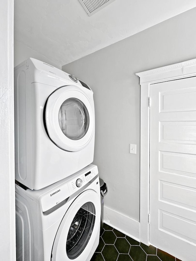 17128 Lukens Rd, Sycamore, IL 60178 - washroom featuring estacked washer and dryer and dark tile patterned floors