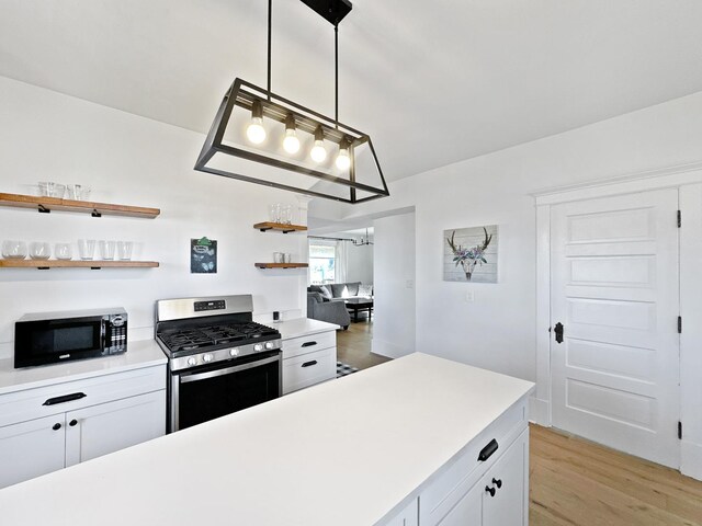17128 Lukens Rd, Sycamore, IL 60178 - kitchen featuring black microwave, gas range, light countertops, light wood-type flooring, and open shelves
