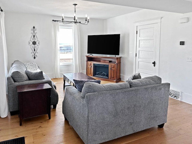 17128 Lukens Rd, Sycamore, IL 60178 - living room with light wood-style flooring, a chandelier, and a fireplace