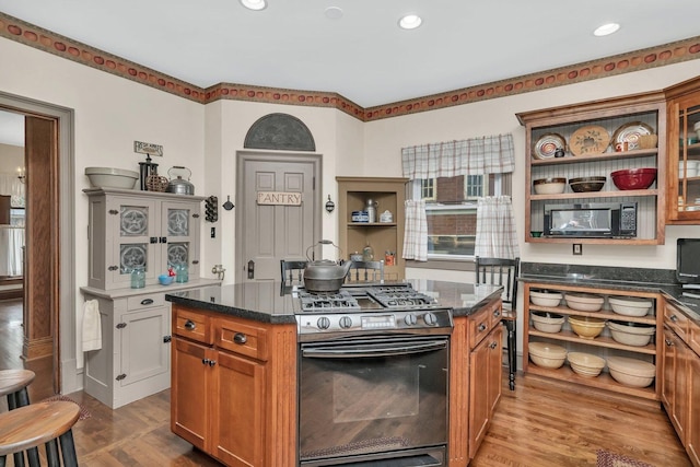 313 N Raynor Ave, Joliet, IL 60435 - kitchen featuring gas stove, open shelves, dark wood-style floors, black microwave, and a kitchen island