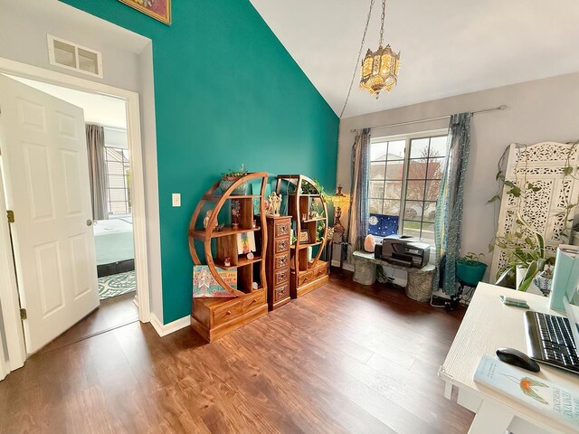648 S Rosehall Ln, Round Lake, IL 60073 - miscellaneous room featuring visible vents, wood finished floors, baseboards, high vaulted ceiling, and a notable chandelier