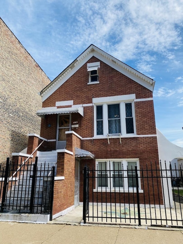 view of front of home featuring brick siding and a fenced front yard