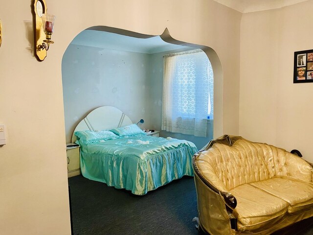 bedroom with carpet flooring and arched walkways