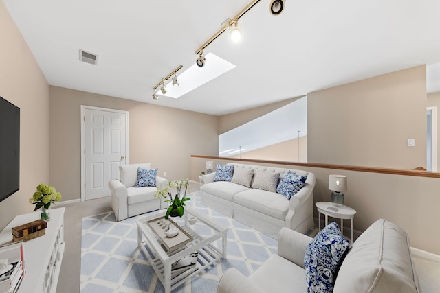 carpeted living area featuring rail lighting, visible vents, baseboards, and a skylight