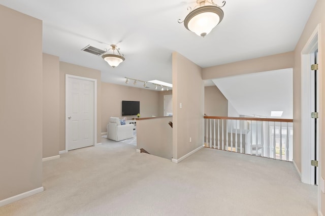 unfurnished room with carpet, visible vents, and baseboards