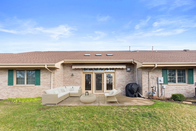 back of house with an outdoor living space, a patio area, brick siding, and a lawn