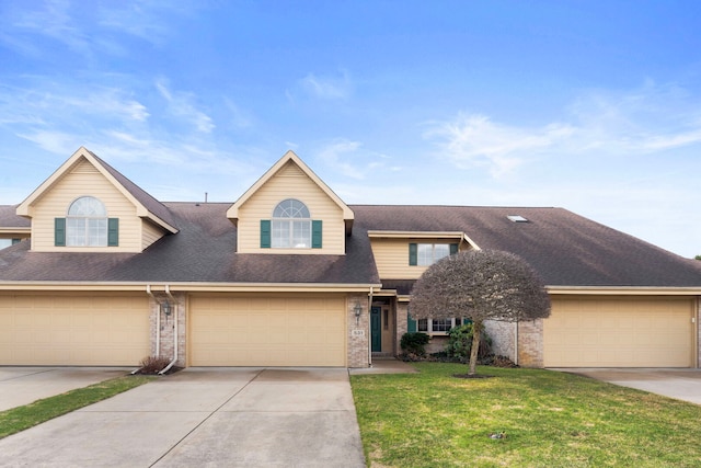 view of front of home featuring a garage, a front lawn, brick siding, a shingled roof, and concrete driveway