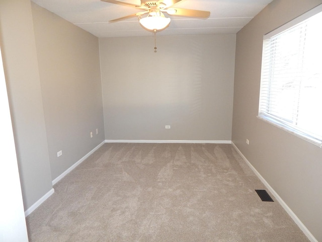 unfurnished room with baseboards, visible vents, carpet floors, and a ceiling fan