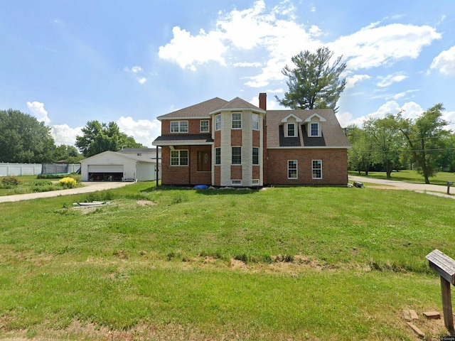 view of front facade with a detached garage, a chimney, a front lawn, fence, and brick siding