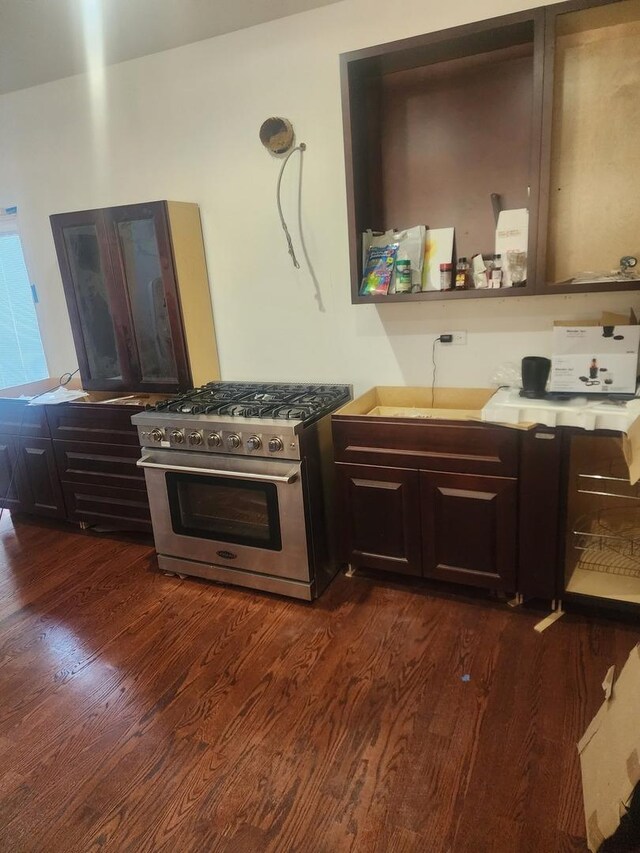 kitchen with high end stainless steel range, a sink, dark wood finished floors, dark brown cabinetry, and light countertops
