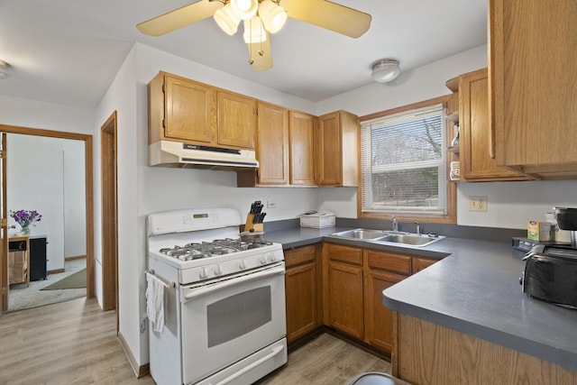 37115 N Sistina Ave, Lake Villa, IL 60046 - kitchen with under cabinet range hood, a sink, dark countertops, and white range with gas stovetop