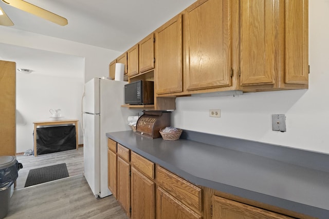 37115 N Sistina Ave, Lake Villa, IL 60046 - kitchen featuring dark countertops, a ceiling fan, black microwave, light wood-type flooring, and freestanding refrigerator