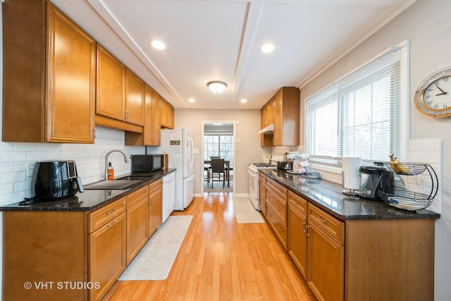 264 Evergreen Ln, Bloomingdale, IL 60108 - kitchen with tasteful backsplash, a sink, white appliances, under cabinet range hood, and light wood-style flooring