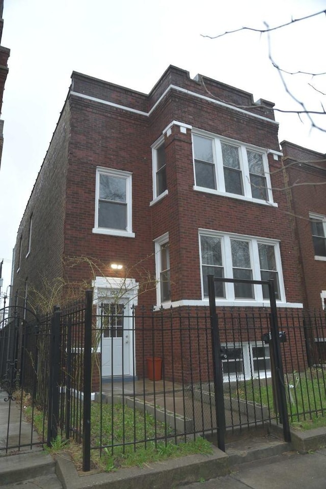 view of front of house featuring a fenced front yard and brick siding