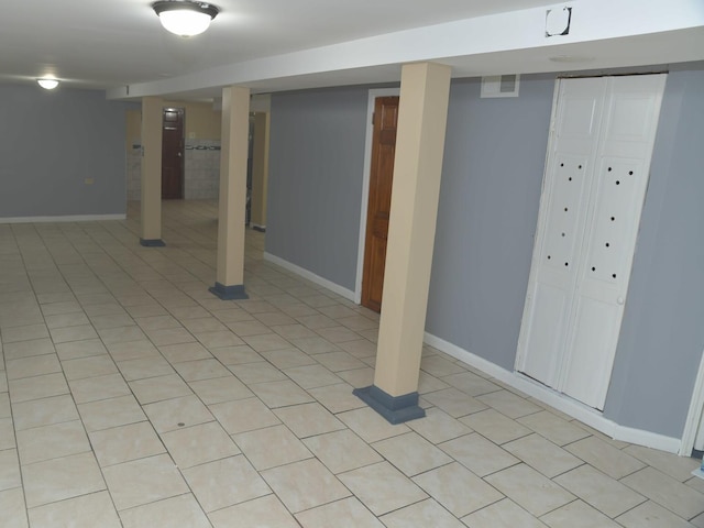 finished below grade area with baseboards, visible vents, and light tile patterned floors