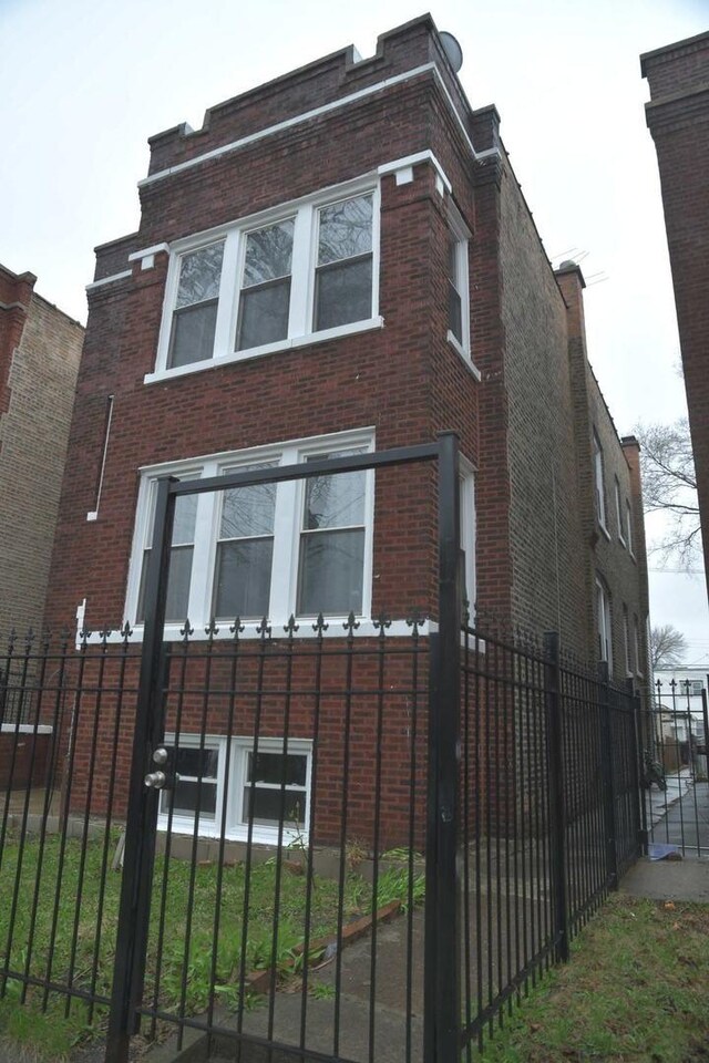 view of property exterior featuring a fenced front yard and brick siding