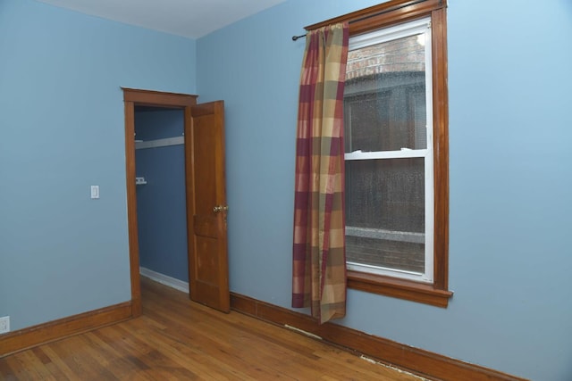 unfurnished room with baseboards and wood finished floors