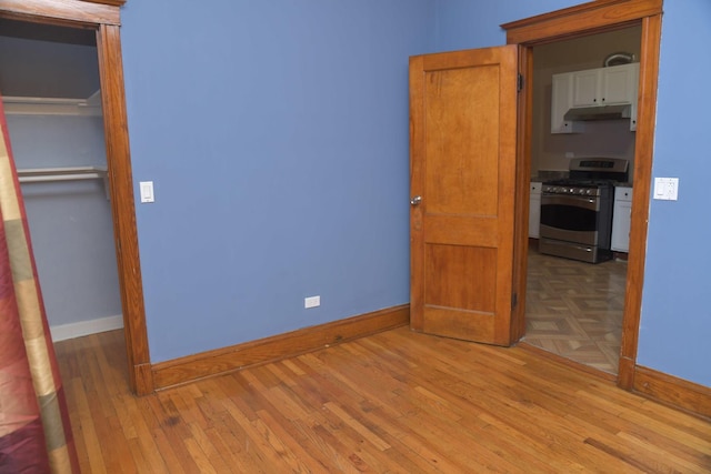 unfurnished bedroom with baseboards and wood finished floors