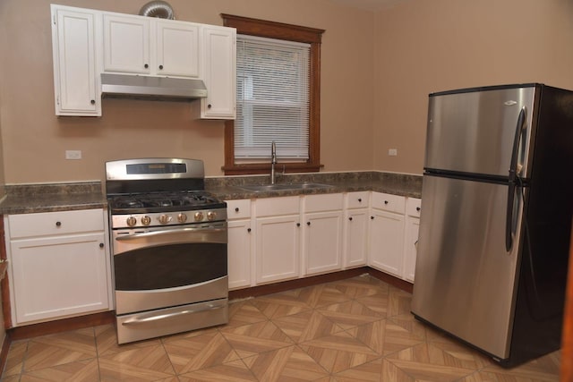 kitchen featuring under cabinet range hood, white cabinets, a sink, and stainless steel appliances