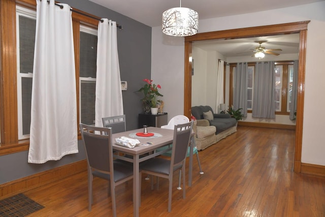 dining room featuring baseboards, ceiling fan, visible vents, and wood-type flooring