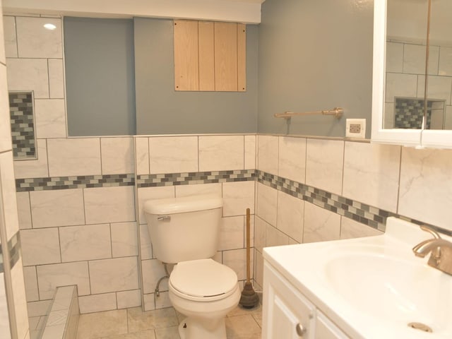 bathroom featuring tile walls, toilet, tile patterned flooring, and vanity