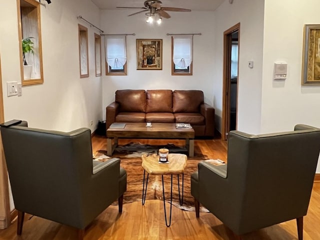 living area with a ceiling fan and light wood-style floors